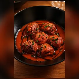 Albóndigas caseras en su salsa en cama de patatas fritas