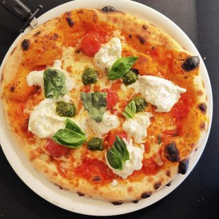 Pizza de burrata con pesto y cherris confitados