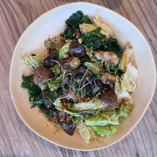 Salteado de gambas con portobello, kale, col borraxona, anacardos y vingreta de azafran 