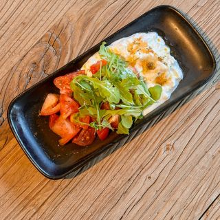 Tomates marinados con stracciatella cremosa hinojo fresco