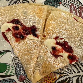 Crepe crema de cheesecake, frutos rojos y galletas
