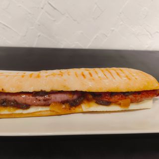 Bocadillo de salchichas, queso, cebolla caramelizada y tartufata