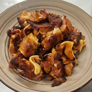 Oreja adobada a la parrilla con ali - oli de piparras