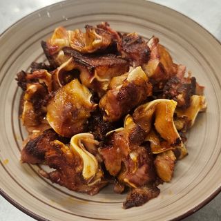 Oreja adobada a la parrilla con ali - oli de piparras