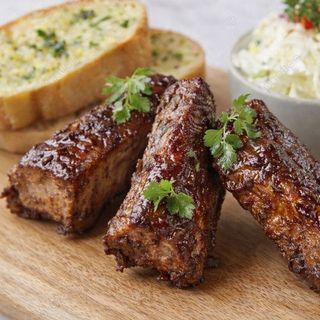 Costillas BBQ Jack Daniel’s con ensalada de col y pan de ajo.