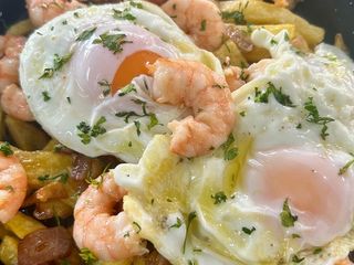 Huevos rotos con langostinos al ajillo