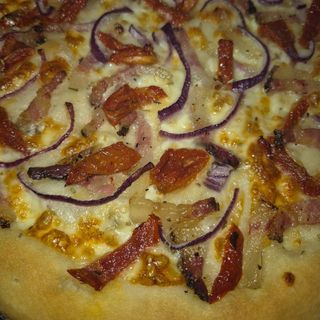 Focaccia guanciale, mozzarella tomate seco y cebolla morada