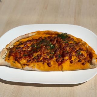 Pizza uzbeka en forma de anillo con queso, champiñones, tomate y hierbas