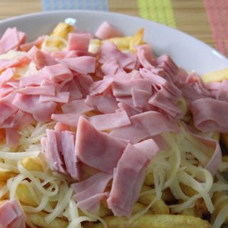 Papas fritas con jamón, queso amarillo y salsas