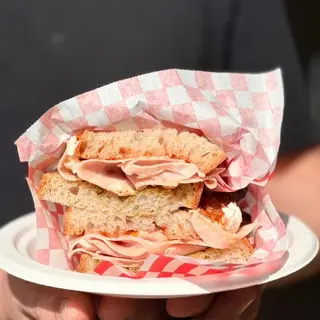 Sándwich de pesto, mortadella de pistacho, tomate seco, mozzarella