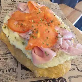 Pizza frita con crema de alcachofa mortadela y tomate