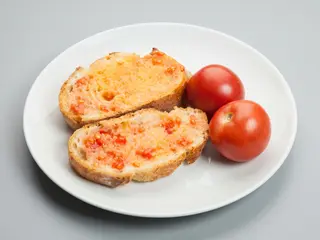 Ración de pan con tomate y aceite de oliva virgen extra.