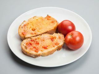 Ración de pan con tomate y aceite de oliva virgen extra.