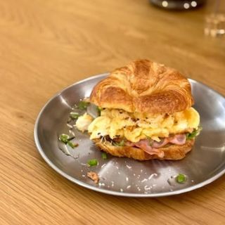Croissant con huevo revuelto , queso y bacon