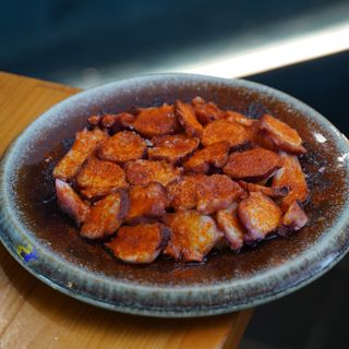 Pulpo A La Gallega servido sobre rodajas de patata con pimentón, aceite de oliva y sal escamada