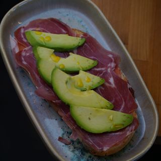 Pan de chía con aguacate, jamón serrano y tomate rallado