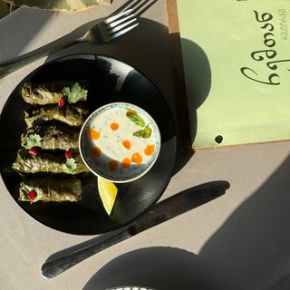 ტოლმა ვაზის ფოთოლში არაჟნის და მაწვნის სოუსით