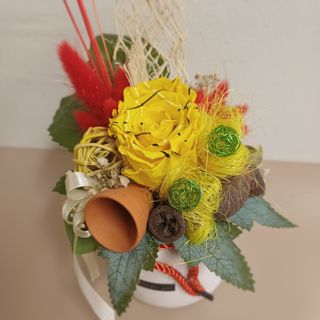 Dehidrirana žuta iscrtana ruža u ukrasnoj posudi