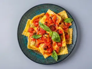 Ravioli con salsa di pomodoro e scaglie di ricotta dura