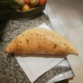 Calzone con prosciutto crudo e rucola, pomodorini e grana