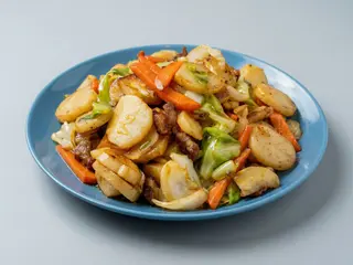 Gnocchi di riso con manzo, verdure e uovo strapazzato 牛肉炒年糕