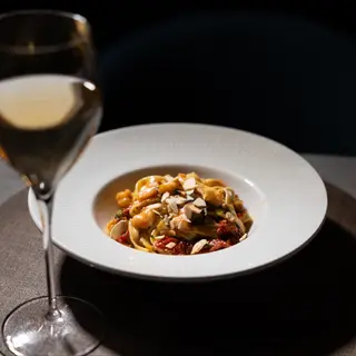 Bavette "Al Raffaello" con gamberi, zucchine, pomodori secchi sott'olio e spolverata di mandorle