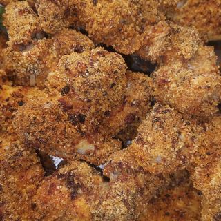 Una porzione da 4 di alette di pollo panate al forno