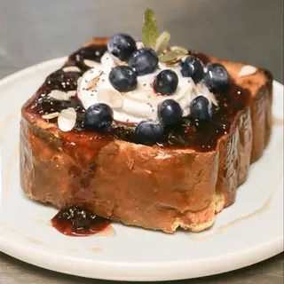 French toast con Yoghurt greco, marmellata ai lamponi, chia, lamelle di mandorla e mirtilli