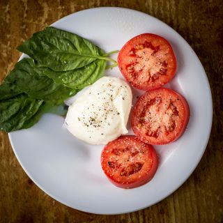 Burrata a piatto con: Pomodoro a Fette e Basilico - servita con Pane-Pizza