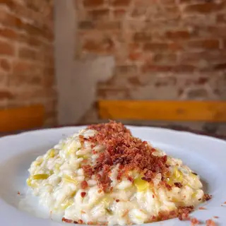 Risotto con Porri, fonduta di Taleggio e Speck Croccante
