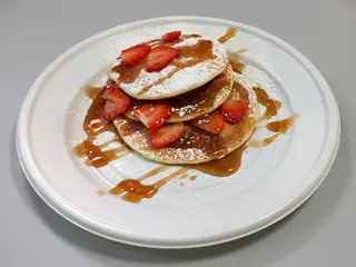 Pancake con fragole fresche, cocco e sciroppo d'acero