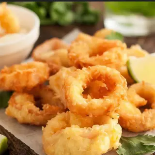 Anelli di calamari fritti con insalata e limone