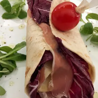 Piadina con prosciutto crudo, mozzarella, salsa rosa, songino o rucola, pomodoro, sale e pepe