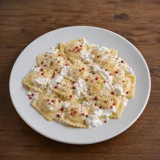 Ravioli ripieni di porchetta con stracciatella e pepe rosa