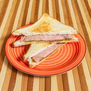 Toast con prosciutto cotto, formaggio fuso, insalata e pomodoro