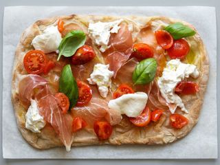 Pinsa con mozzarella fiordilatte, pomodoro fresco, rucola prosciutto crudo