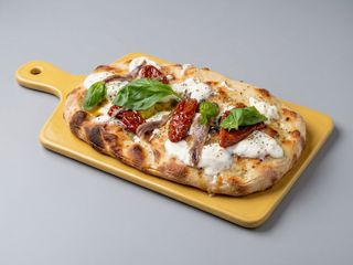 Pinsa con burrata, olive, capperi, pomodori secchi e acciughe