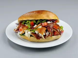 Panino con carne, patatine, verdure e salse