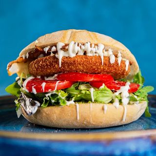 Burger di pollo, pesto di pistacchio, insalata, pomodoro a fette, bacon croccante e mayo