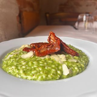 Risotto con pesto di rucola, mandorle e pomodorini confit
