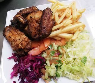 Piatto con alette di pollo con patate e insalata