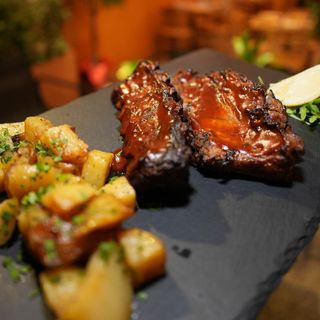 Ribes di maiale con salsa BBQ e patate al fornom