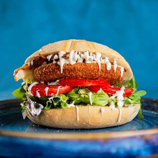 Burger di pollo, pesto di pistacchio, insalata, pomodoro a fette, bacon croccante e mayo