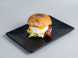 Panino con hamburger, cheddar, bacon, insalata e uova