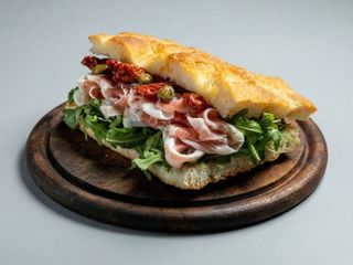 Panino con mozzarella, pancetta, patate, pomodorini e rucola