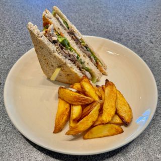 BBQ club sandwichclub sandwich ai cereali farcito con il nostro pollo cotto a bassa temperatura, bacon croccante, brie caldo, funghi, misticanza, citronette, delicata salsa barbecue, servito con patate rustiche al forno