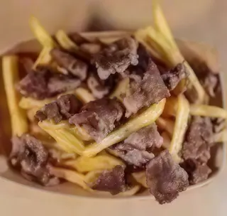 Piatto elaborato con patatine fritte e doppia tagliata di hamburger da