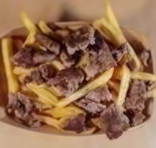 Piatto elaborato con patatine fritte e doppia tagliata di hamburger da