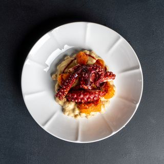 Polpo fondente al merlot su crema di patate e ceci, con zucca arrosto ed erbe
