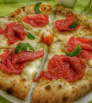 Trancio di pizza rossa con salame toscano